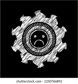 sad face icon drawn on blackboard