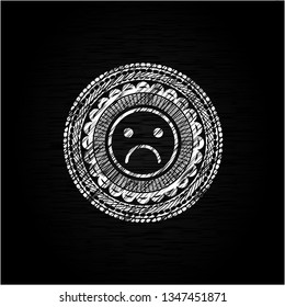 sad face icon drawn on a chalkboard