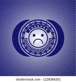 sad face icon inside badge with jean texture