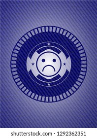 sad face icon inside badge with jean texture