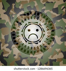 sad face icon inside camouflaged emblem
