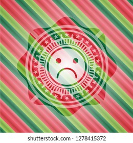 sad face icon inside christmas style emblem.
