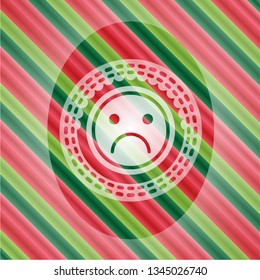 sad face icon inside christmas style badge..