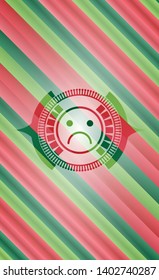 sad face icon inside christmas colors badge.