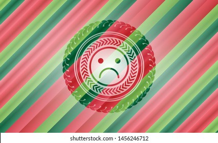 sad face icon inside christmas emblem.