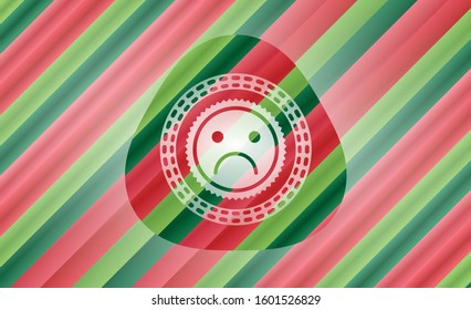 sad face icon inside christmas colors badge.