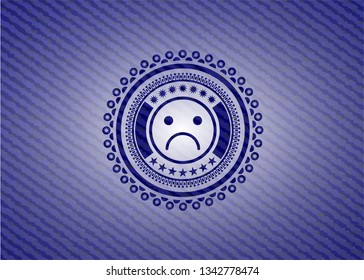 sad face icon inside denim background