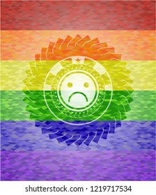 sad face icon inside emblem on mosaic background with the colors of the LGBT flag