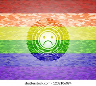 sad face icon inside emblem on mosaic background with the colors of the LGBT flag