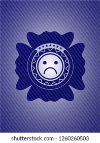 sad face icon inside emblem with jean background
