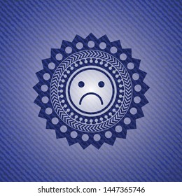 sad face icon inside emblem with denim high quality background