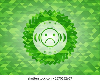 sad face icon inside green emblem with mosaic background