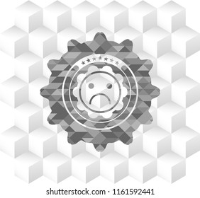 sad face icon inside grey emblem with geometric cube white background