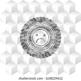 sad face icon inside grey emblem with geometric cube white background