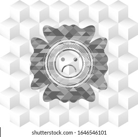 sad face icon inside grey emblem with geometric cube white background