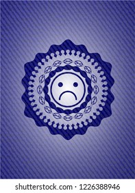 sad face icon inside jean or denim emblem or badge background