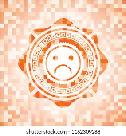 sad face icon inside orange mosaic emblem