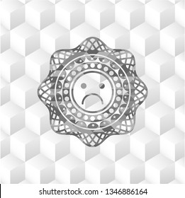 sad face icon inside realistic grey emblem with cube white background