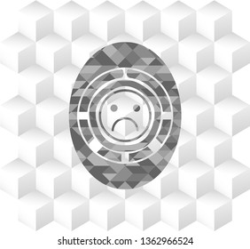sad face icon inside realistic grey emblem with cube white background