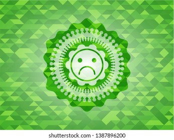 sad face icon inside realistic green mosaic emblem