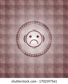 sad face icon inside red seamless emblem or badge with geometric pattern background. 