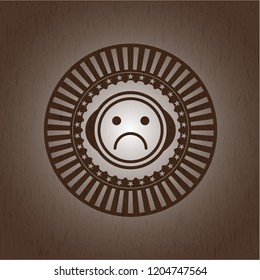 sad face icon inside retro style wooden emblem