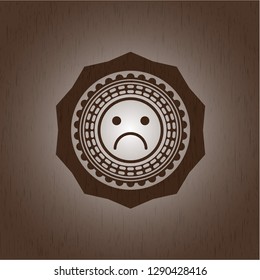sad face icon inside retro wooden emblem
