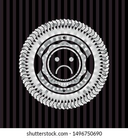 sad face icon inside silver emblem or badge