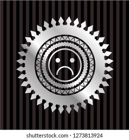 sad face icon inside silvery badge