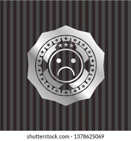sad face icon inside silvery emblem