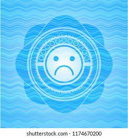 sad face icon inside sky blue water emblem.