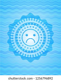sad face icon inside sky blue water style emblem.