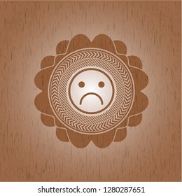 sad face icon inside vintage wooden emblem