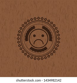 sad face icon inside vintage wood emblem