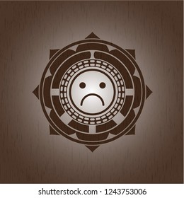 sad face icon inside wood emblem