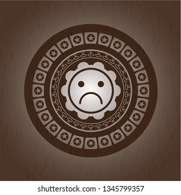 sad face icon inside wood emblem