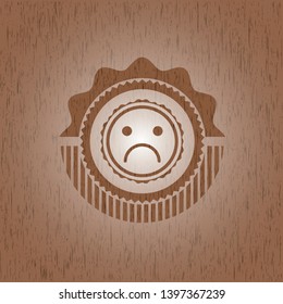 sad face icon inside wood badge or emblem