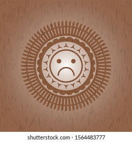 sad face icon inside wood emblem
