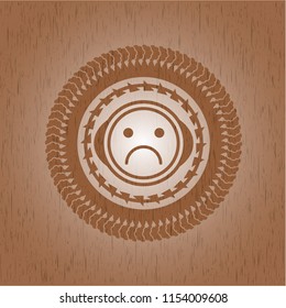 sad face icon inside wooden emblem. Retro