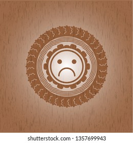 sad face icon inside wooden emblem. Vintage.