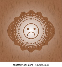 sad face icon inside wooden emblem. Vintage.