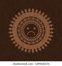 sad face icon inside wooden emblem. Retro