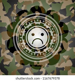 sad face icon on camouflage pattern