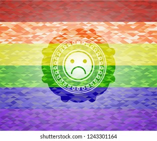 sad face icon on mosaic background with the colors of the LGBT flag