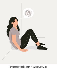 Sad girl sitting with her back against the wall