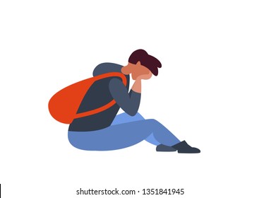 Sad guy with a backpack sitting on the floor. Depression, negative emotions, loneliness in adolescence, at school