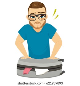 Sad looking man sweating packing clothes on suitcase