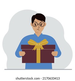 Un hombre triste sostiene una gran caja de regalo con un arco en las manos. Ilustración plana del vector
