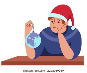 a sad man sits in a Santa's hat and looks at the New Year's ball, worries, worries about the future of planet Earth, because of threat of a nuclear explosion, an environmental disaster.