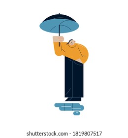 Sad man standing with umbrella and looking at puddles during rain